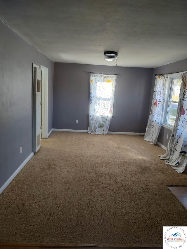 carpeted spare room with baseboards