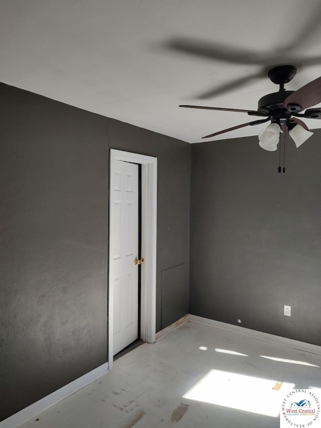 unfurnished room featuring concrete flooring and baseboards