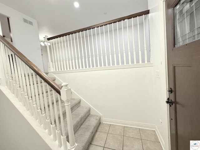 staircase featuring visible vents, baseboards, and tile patterned floors