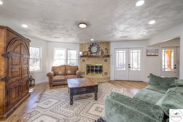 living room featuring french doors, a textured ceiling, and hardwood / wood-style flooring