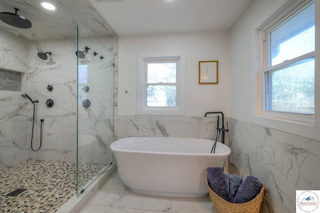 full bath featuring a marble finish shower, a soaking tub, recessed lighting, wainscoting, and marble finish floor