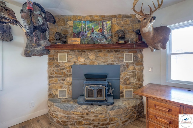 details featuring visible vents, a wood stove, and wood finished floors