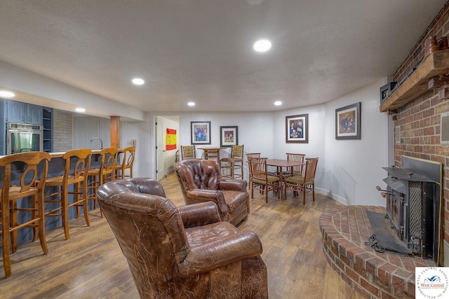 living area featuring recessed lighting, baseboards, a textured ceiling, and wood finished floors