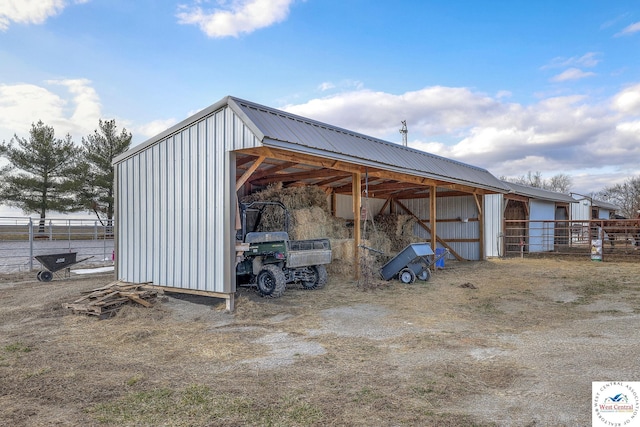 view of pole building with a detached carport and fence