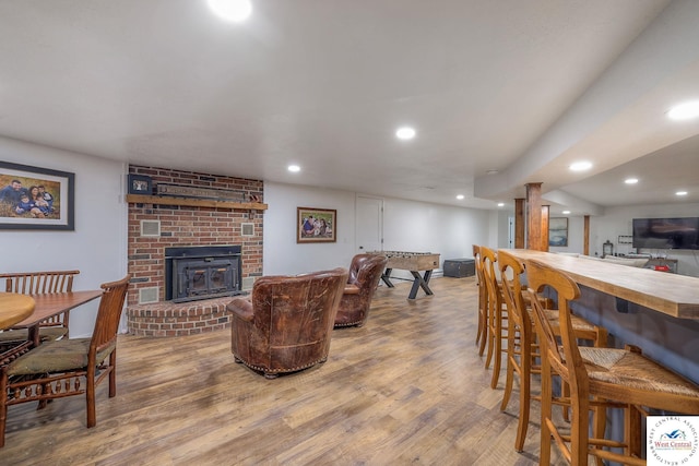 living area with recessed lighting, wood finished floors, and a fireplace