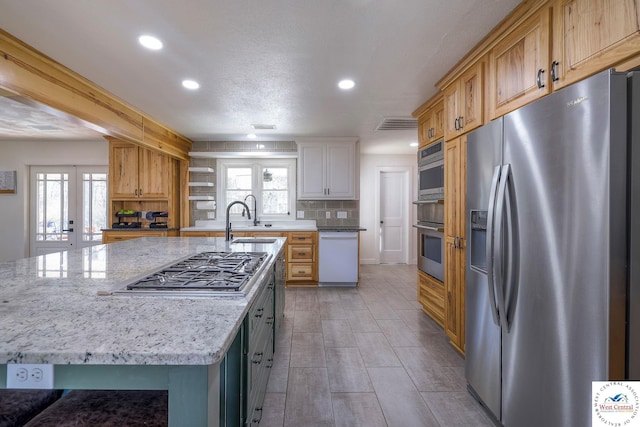 kitchen featuring a wealth of natural light, stainless steel appliances, tasteful backsplash, and a sink