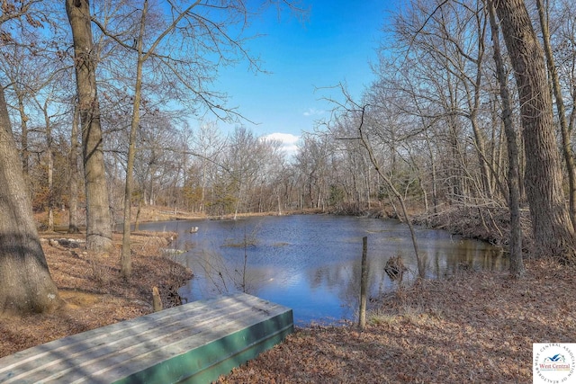 view of dock featuring a forest view and a water view