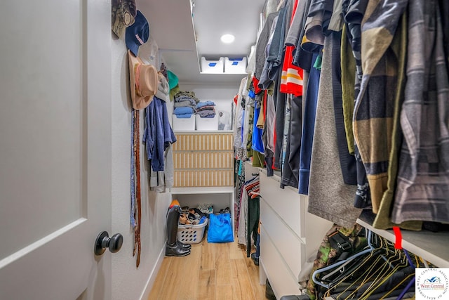 walk in closet with wood finished floors