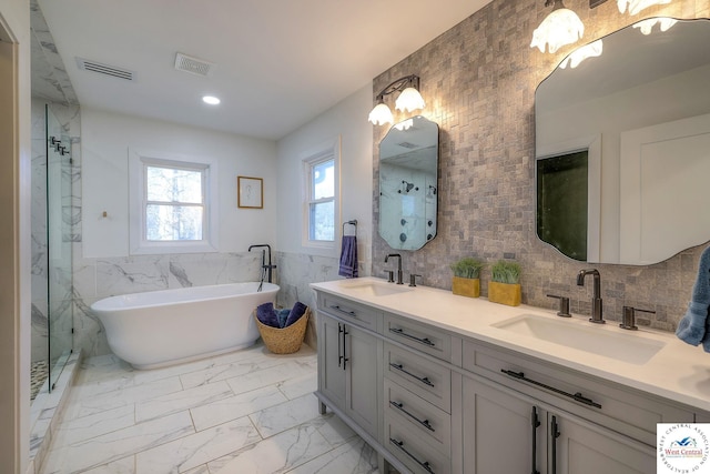 full bath with tile walls, visible vents, marble finish floor, and a sink