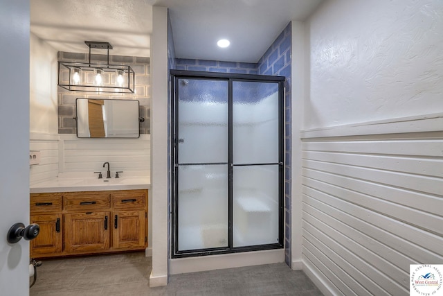 full bath featuring tile patterned floors, vanity, and a shower stall