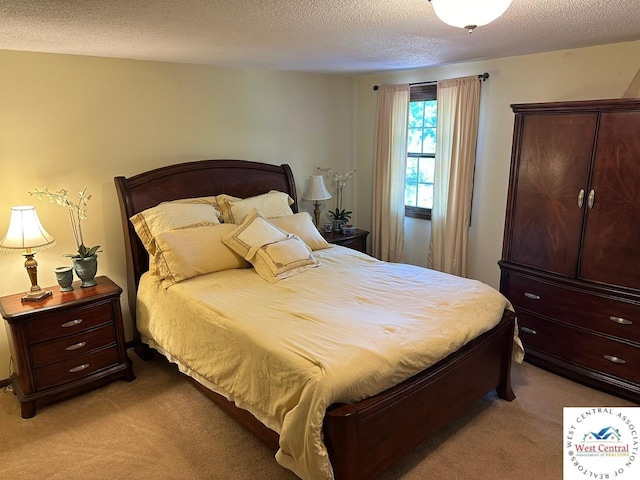 bedroom featuring a textured ceiling and light colored carpet