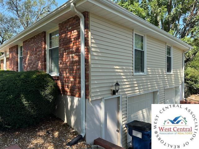 view of side of home with brick siding and an attached garage