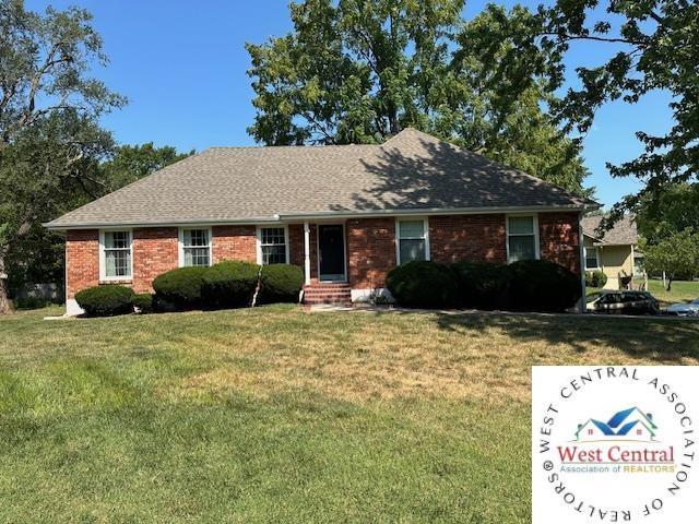 ranch-style home with brick siding and a front lawn