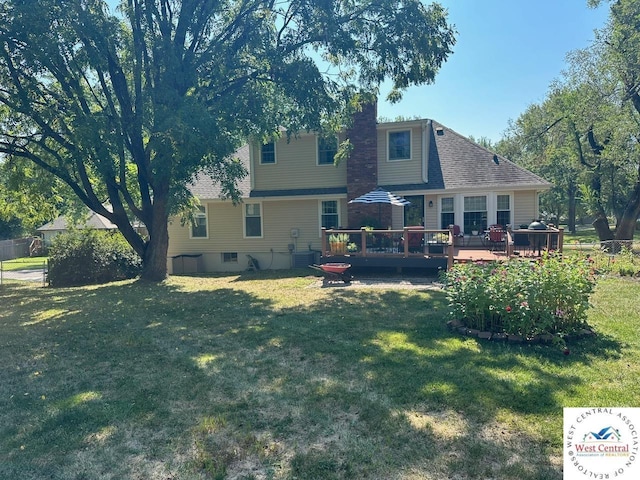 rear view of property featuring a deck, a yard, a chimney, and central air condition unit