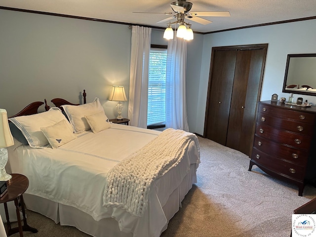 bedroom featuring a closet, a ceiling fan, crown molding, and carpet flooring