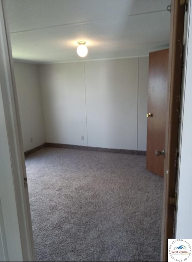 empty room featuring carpet floors and baseboards