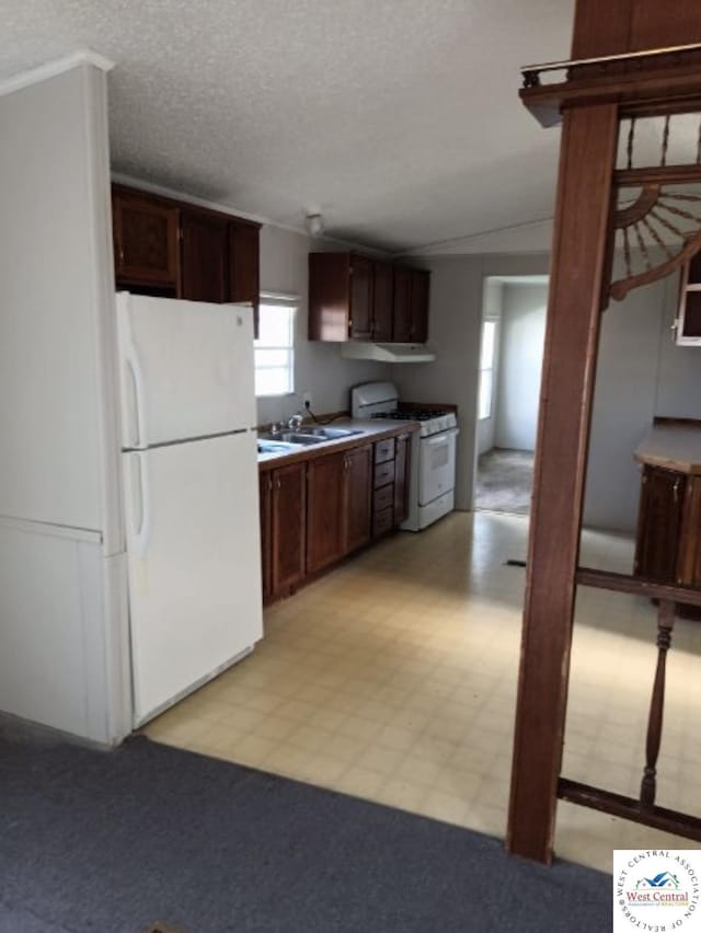 kitchen with white appliances, light countertops, a sink, and light floors