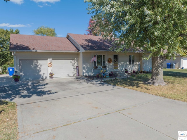 ranch-style home featuring driveway, a porch, roof with shingles, an attached garage, and a front lawn