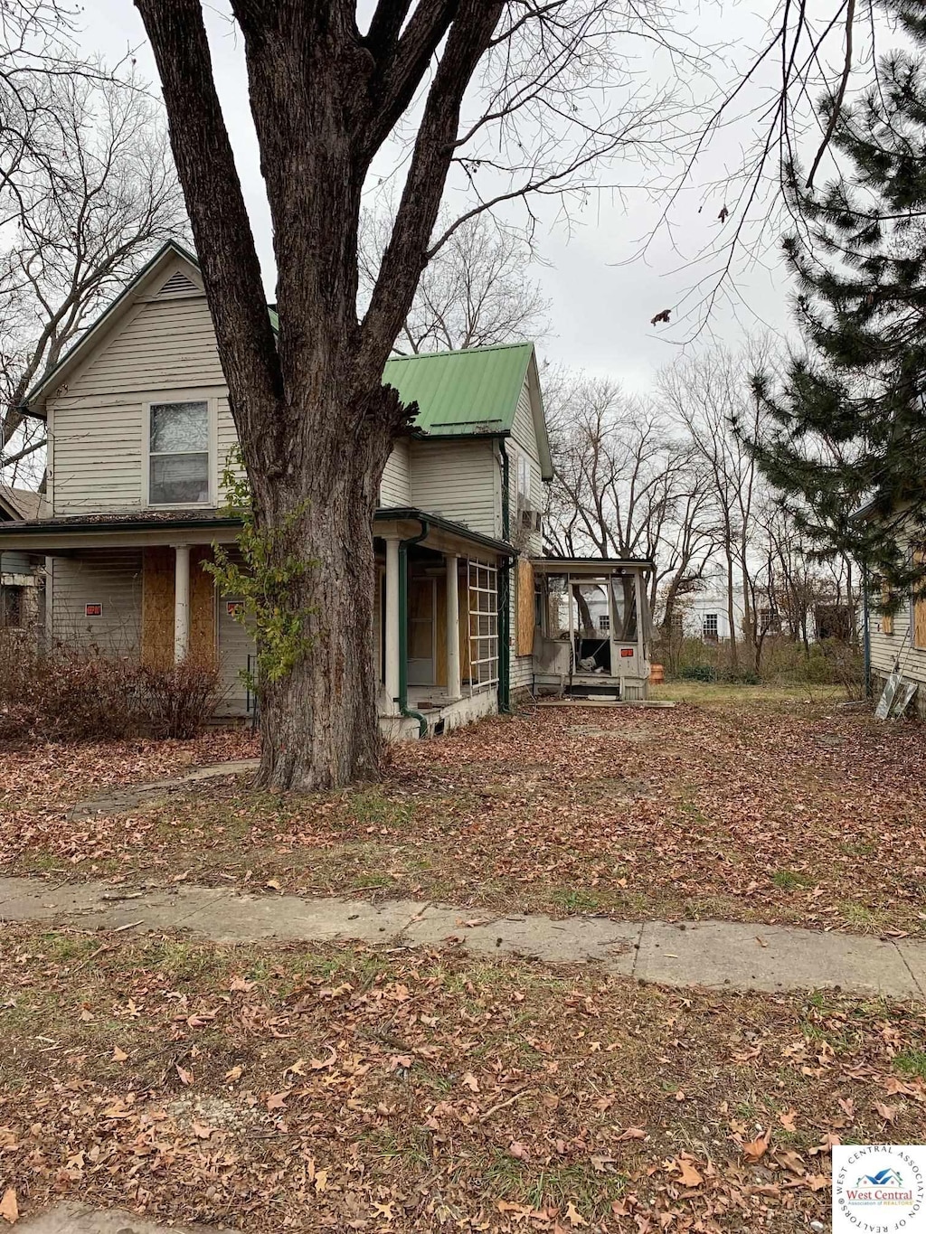 view of home's exterior featuring a garage, covered porch, and metal roof