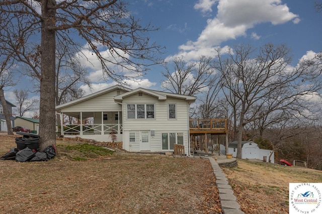 view of front of property with an outbuilding, a front lawn, a storage unit, a deck, and a patio area