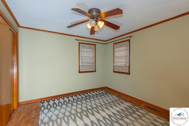 unfurnished room featuring visible vents, crown molding, and baseboards