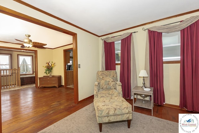 living area with ornamental molding, baseboards, and wood finished floors