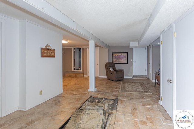 interior space featuring stone finish flooring, baseboards, and a textured ceiling