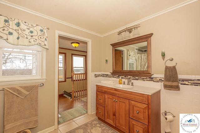 bathroom with vanity, a wainscoted wall, ornamental molding, tile patterned floors, and tile walls