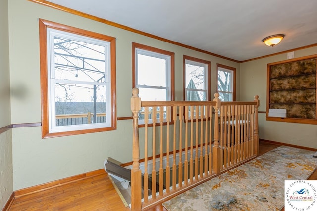 staircase featuring crown molding, baseboards, and wood finished floors