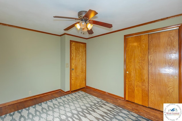 unfurnished bedroom with crown molding, wood finished floors, and baseboards