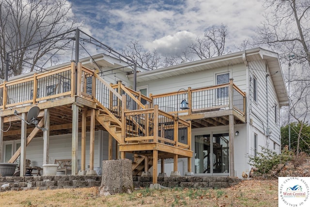 rear view of property featuring stairs and a deck