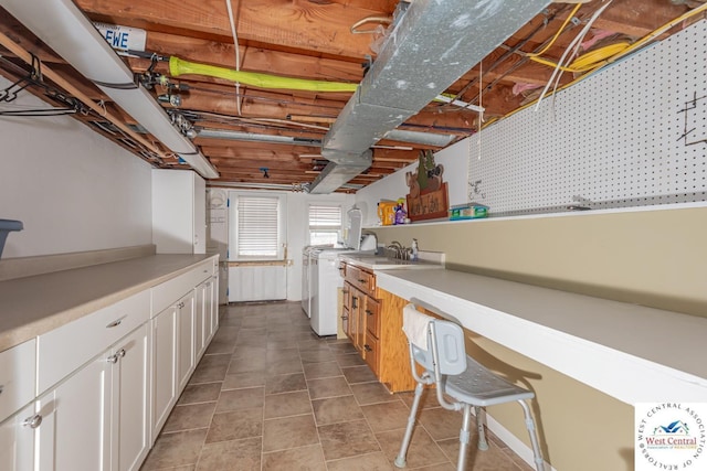 kitchen with a sink, white cabinetry, tile patterned flooring, range, and light countertops