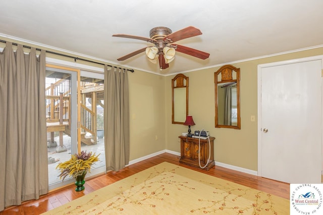 entryway with ceiling fan, baseboards, wood finished floors, and crown molding