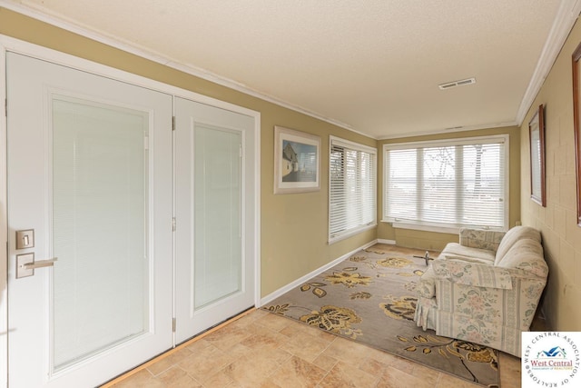 sitting room featuring a textured ceiling, baseboards, visible vents, and ornamental molding