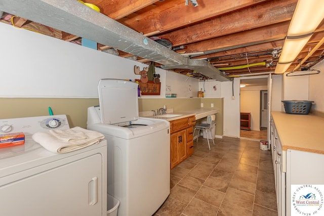 laundry room featuring separate washer and dryer, cabinet space, and a sink