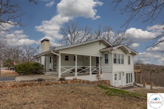 bungalow featuring a porch and a chimney