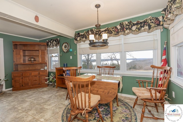 dining room featuring crown molding, baseboards, and a chandelier