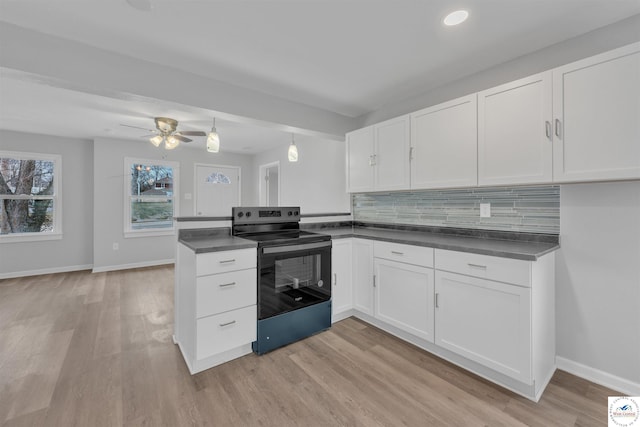 kitchen featuring black electric range, dark countertops, white cabinets, and backsplash