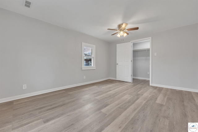 unfurnished bedroom featuring baseboards, visible vents, ceiling fan, light wood-type flooring, and a closet