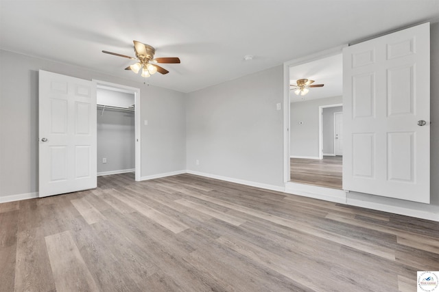 unfurnished bedroom with ceiling fan, wood finished floors, and baseboards