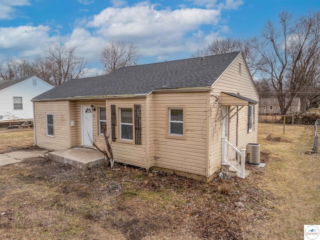 view of front of house featuring a shingled roof, entry steps, and central AC unit