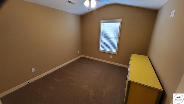 unfurnished room with ceiling fan, visible vents, baseboards, vaulted ceiling, and dark carpet