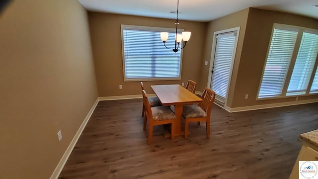 dining area featuring an inviting chandelier, baseboards, and dark wood-type flooring