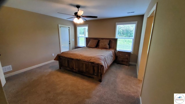 bedroom with ceiling fan, light colored carpet, visible vents, and baseboards