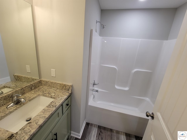 bathroom featuring wood finished floors, shower / tub combination, and vanity