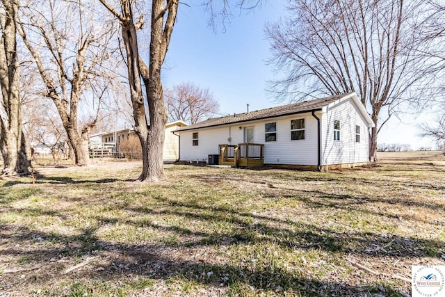 back of property with cooling unit and a yard