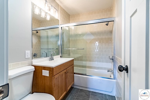 bathroom featuring enclosed tub / shower combo, toilet, and vanity