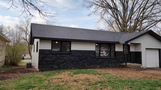 view of front facade with a garage, stone siding, roof with shingles, and cooling unit