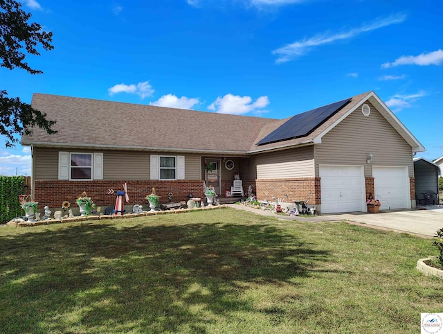 ranch-style home with a front yard, roof mounted solar panels, and brick siding