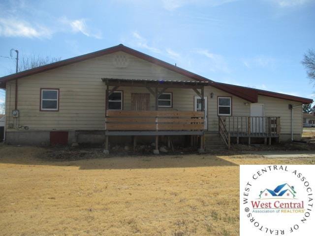 rear view of property with a yard and a wooden deck